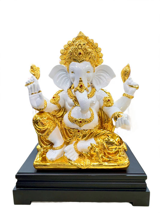 Decorative Ganesha statue of a deity with gold and white colors on a black base.