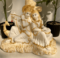 Decorative statue of a couple with gold accents on a neutral background