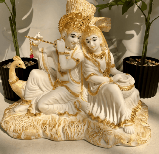 Decorative statue of a couple with gold accents on a neutral background