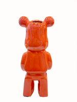 Orange ceramic bear sculpture with glossy piggy bank.