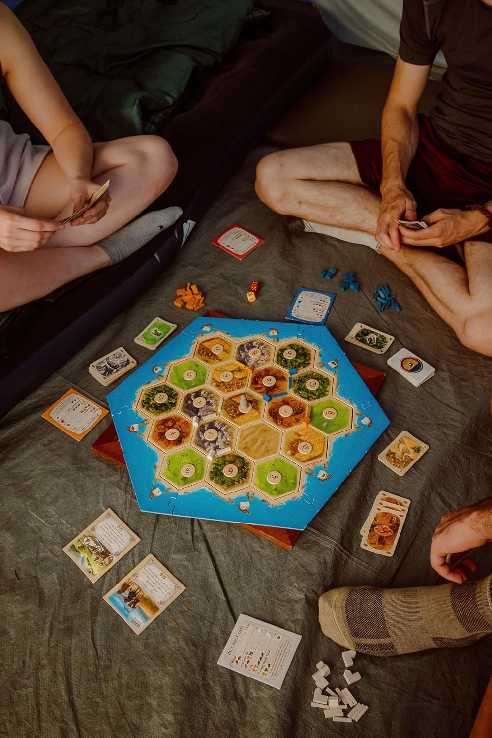 Family playing the Catan strategy game at home