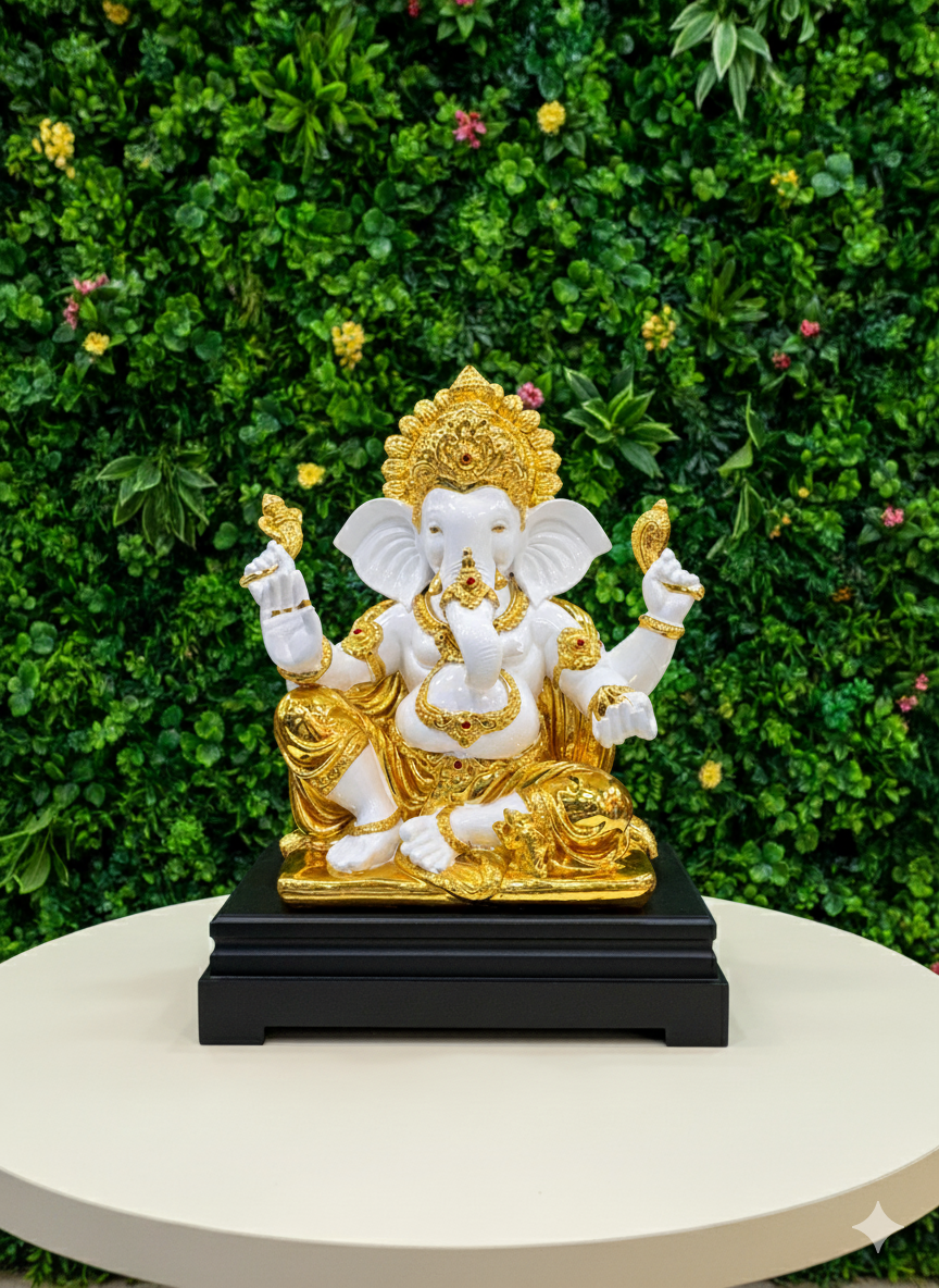 Decorative Ganesha statue of a seated figure with gold and white details on a black base.