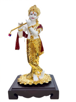 Statue of a deity in gold and white attire on a wooden base with a white background