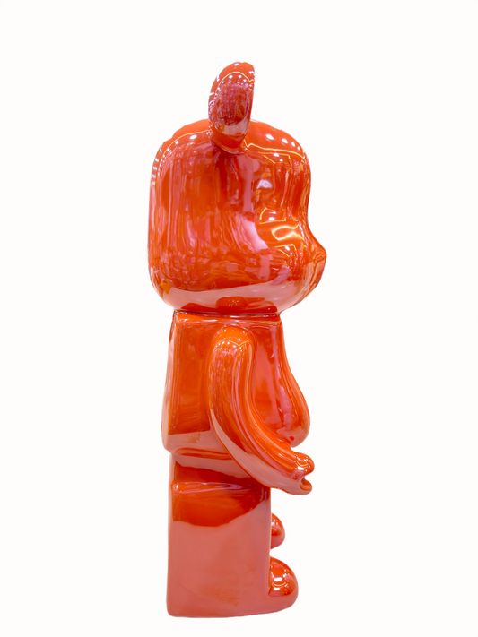 Orange ceramic bear sculpture with glossy piggy bank.