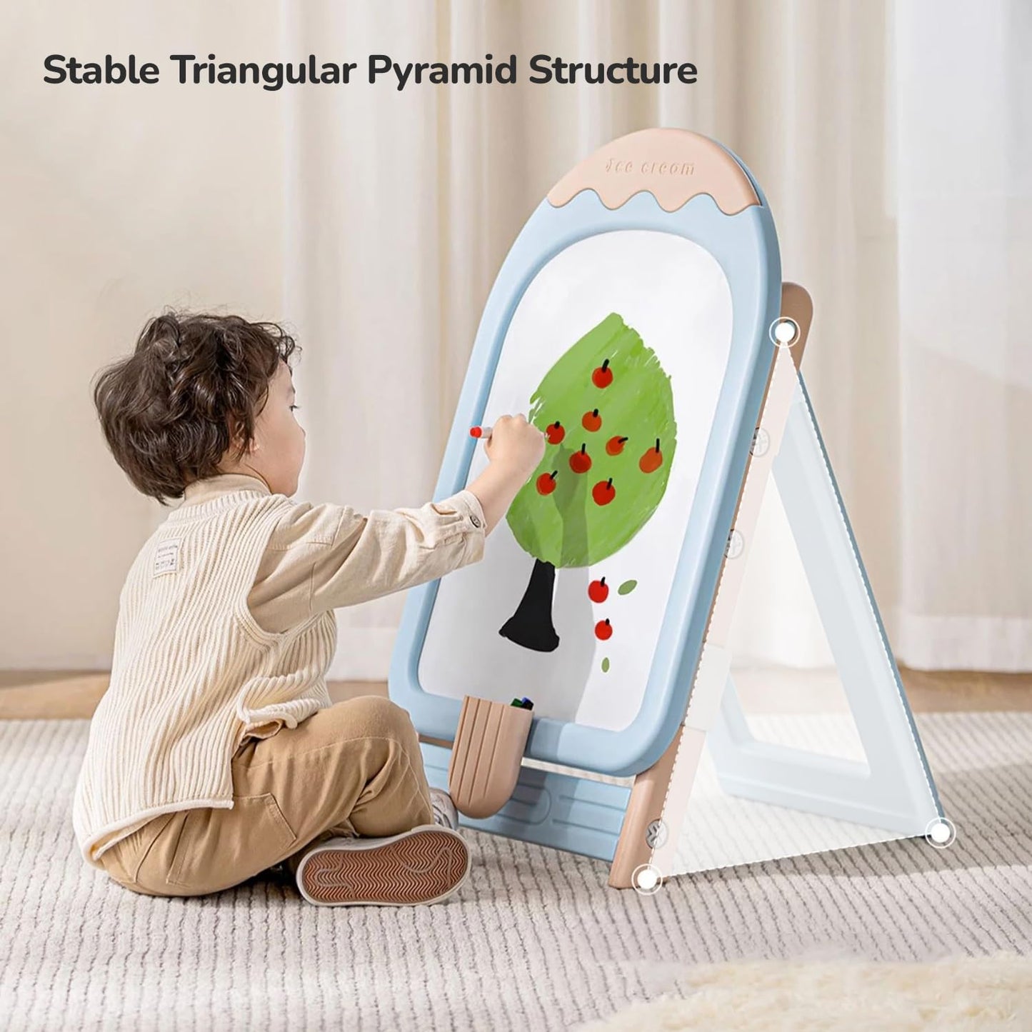 A young child sitting on the blue chair and happily drawing on the magnetic whiteboard of the R for Rabbit Little Genius Easel.