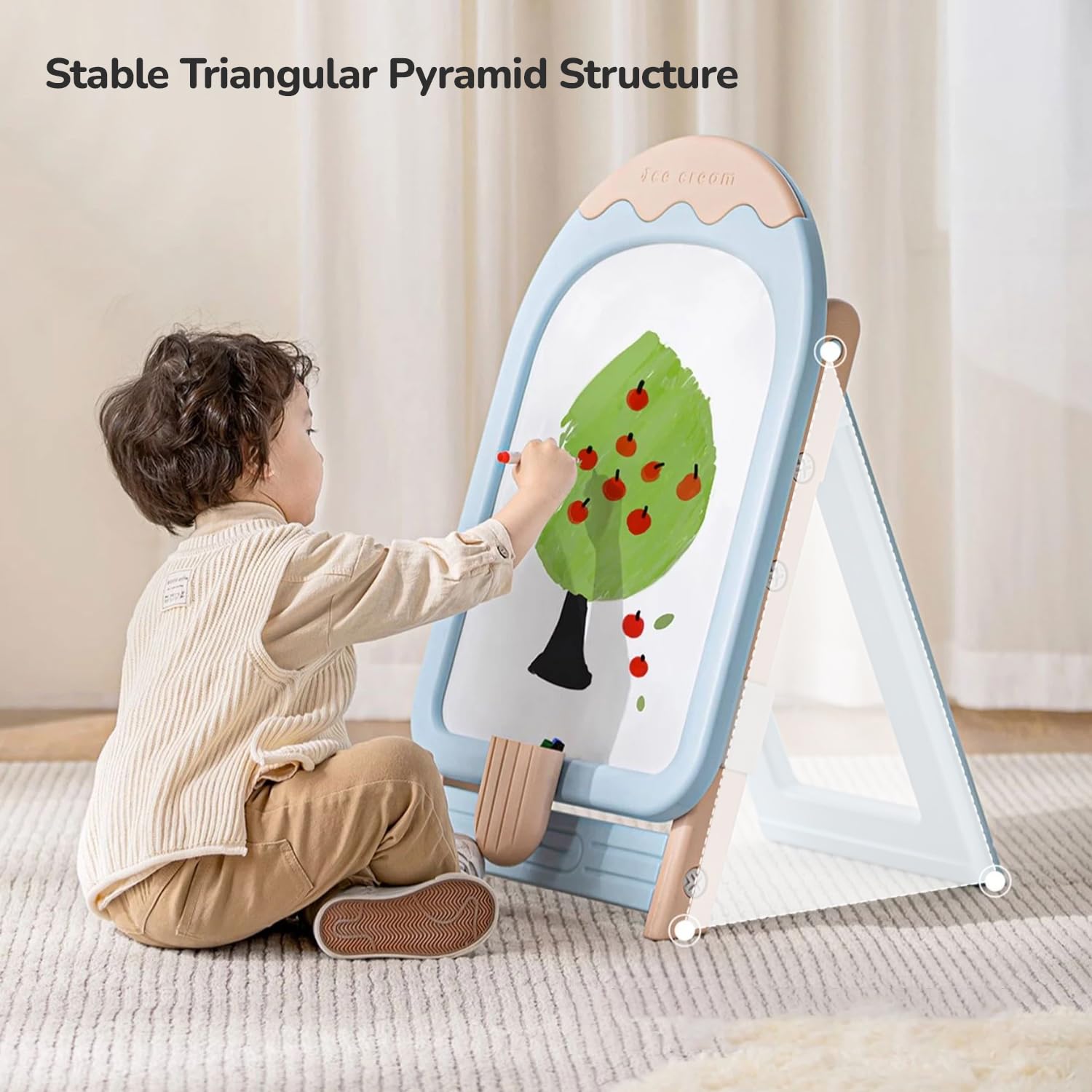 A young child sitting on the blue chair and happily drawing on the magnetic whiteboard of the R for Rabbit Little Genius Easel.