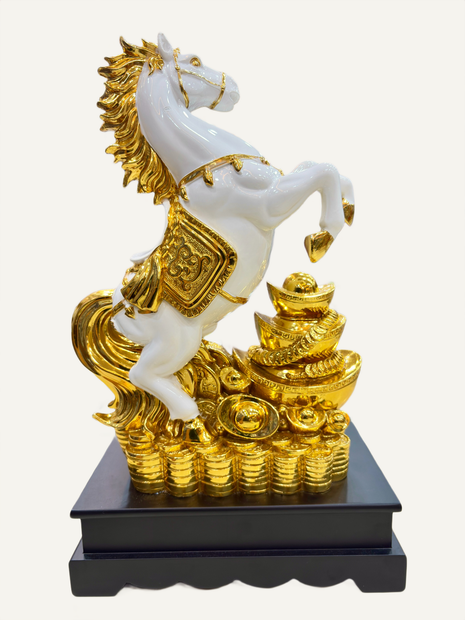Decorative statue of a white horse with gold accents on a black base